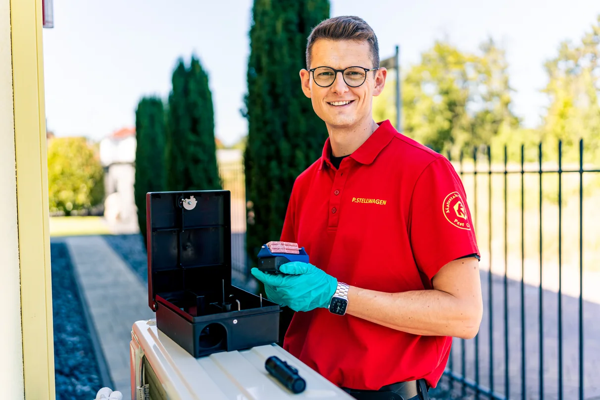Geöffnete Köderstation in der Hand eines Technikers