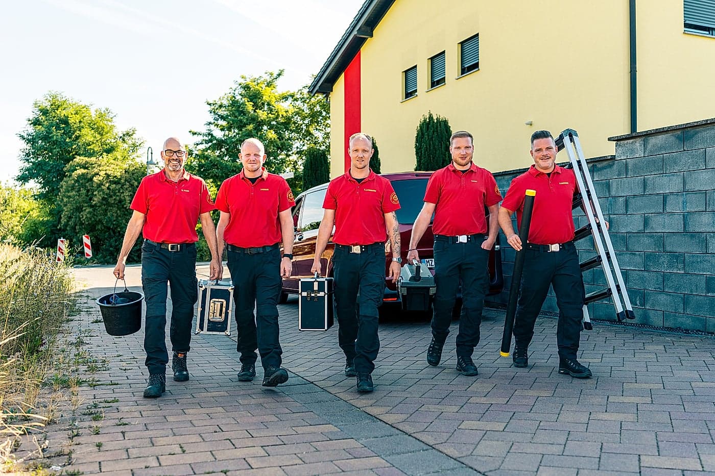 Fünf Mitarbeitende der Matuszak Hygiene mit Ausrüstungskoffern vor dem Betrieb