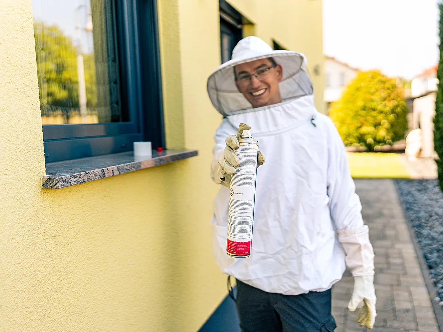 Mitarbeiter im Schutzanzug bei der Arbeit an der Hausfassade